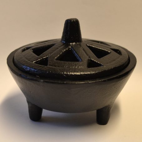 Schwarze, runde Schale mit drei Beinen und ausgeschlossenen Mustern auf dem Deckel.